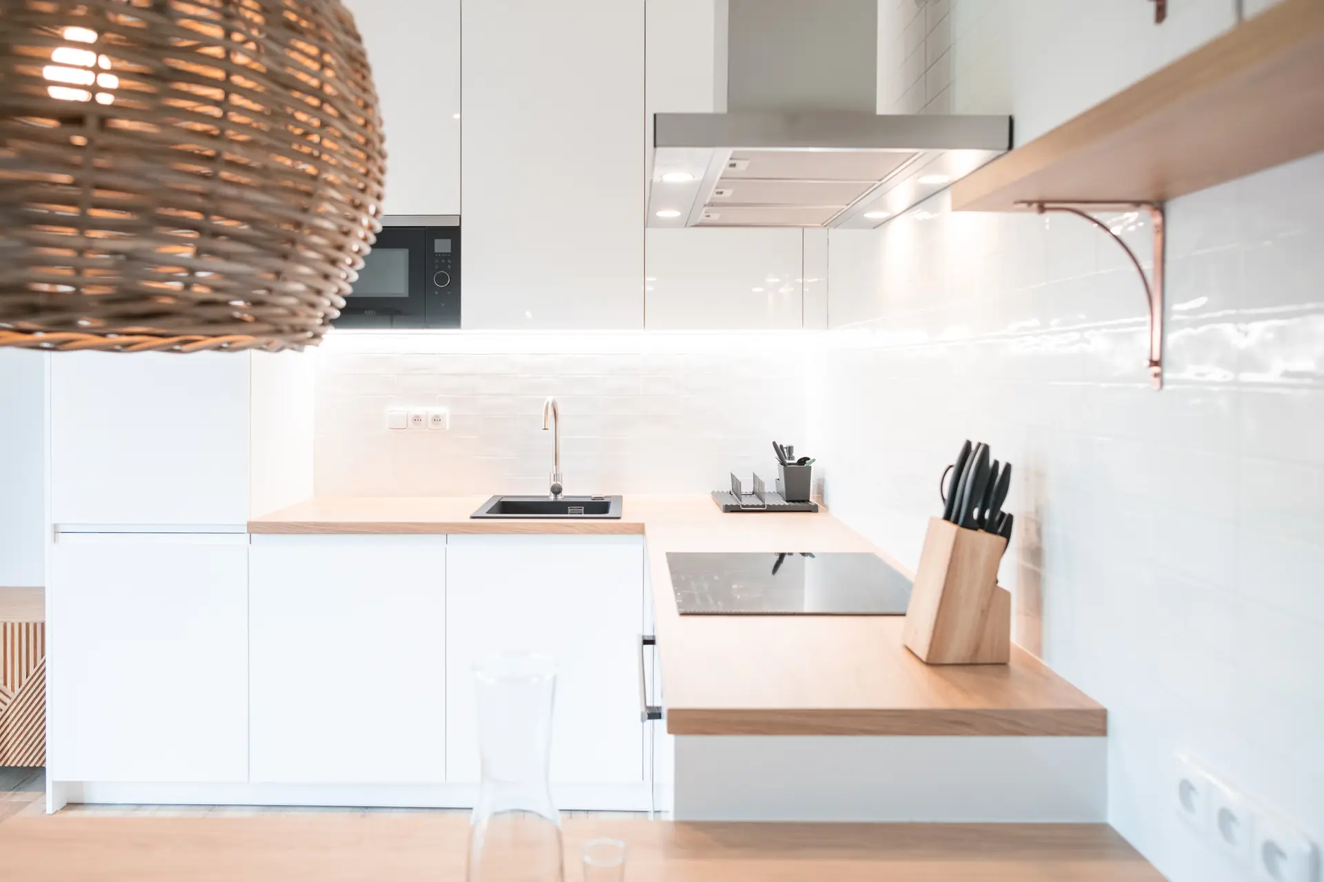 White kitchen with a rattan pendant light